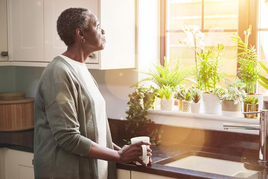 Woman looking out kitchen window