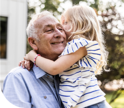 Smiling grandpa playing with his granddaughter